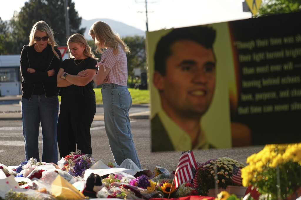 Women pray at a memorial outside Utah Valley University after Turning Point USA CEO and co-founder Charlie Kirk was shot and killed, Saturday, Sept. 13, 2025, in Orem, Utah. (AP Photo/Lindsey Wasson)