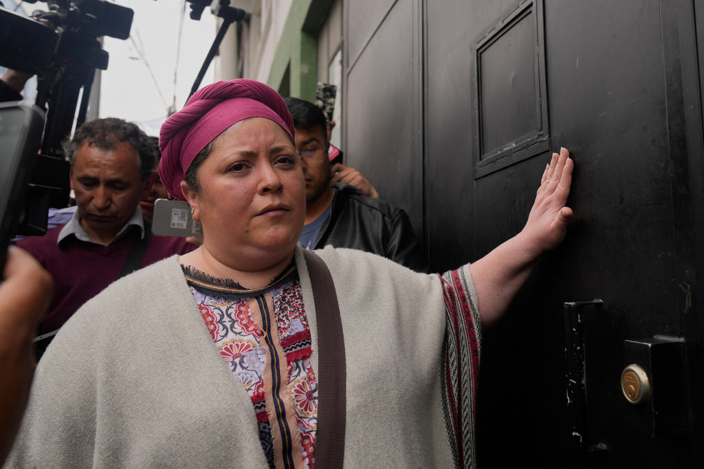 Former minister of the presidency Maria Nela Prada knocks on the door at the police station, after former President Luis Arce was arrested for corruption in La Paz, Bolivia, Wednesday, Dec. 10, 2025. (AP Photo/Juan Karita)