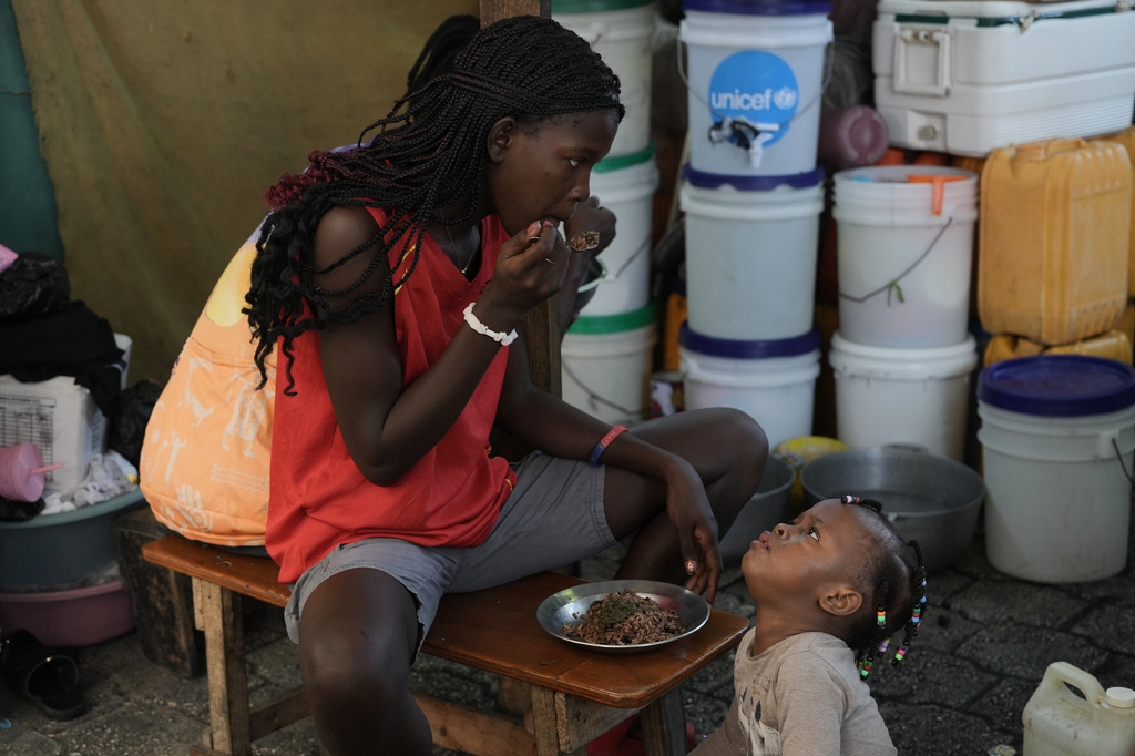 Children eat at a shelter for families displaced by gang violence in Port-au-Prince, Haiti, Wednesday, Aug. 19, 2026. (AP Photo/Odelyn Joseph)