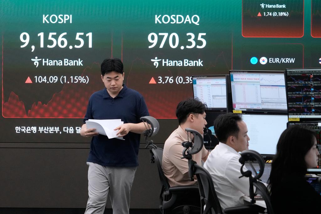 A currency trader passes by a screen showing the Korea Composite Stock Price Index (KOSPI) at the foreign exchange dealing room of the Hana Bank headquarters in Seoul, South Korea, Monday, June 22, 2026. (AP Photo/Ahn Young-joon)
