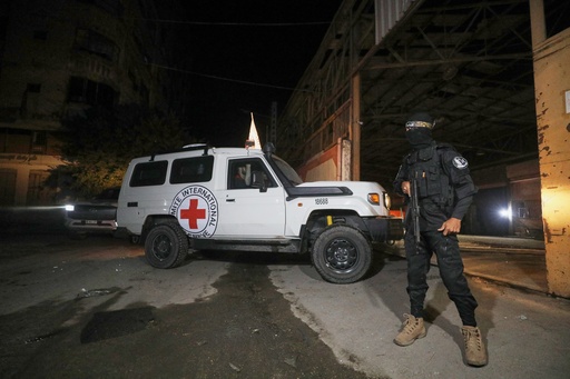 A gunman wearing the uniform of the al-Qassam Brigades, the military wing of Hamas, stands guard as Red Cross vehicles enter a warehouse allegedly to collect coffins containing the bodies of four deceased hostages, in Gaza City, Tuesday, Oct. 14, 2025. (AP Photo/Yousef Al Zanoun) A gunman wearing the uniform of the al-Qassam Brigades, the military wing of Hamas, stands guard as Red Cross vehicles enter a warehouse allegedly to collect coffins containing the bodies of four deceased hostages, in Gaza City, Tuesday, Oct. 14, 2025. (AP Photo/Yousef Al Zanoun)