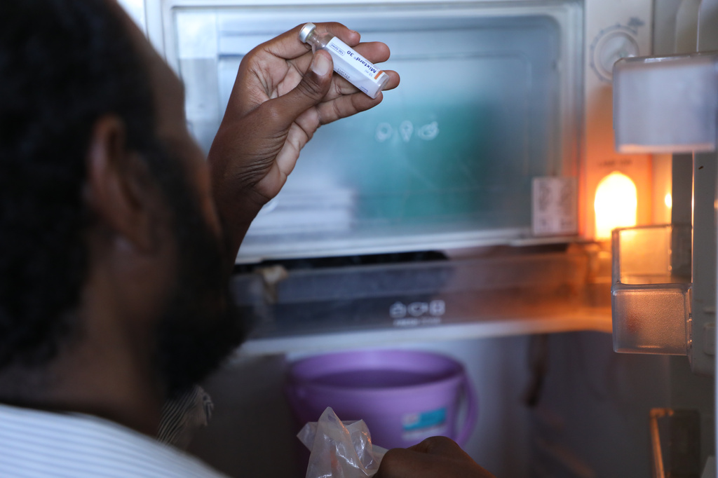 Al-Hodabi Yassin, a diabetes patient, checks an insulin injection stored in his refrigerator during an electricity shortage, in Omdurman, on the outskirts of Khartoum, Sudan, July 24, 2026. (AP Photo/Mohnd Blal)
