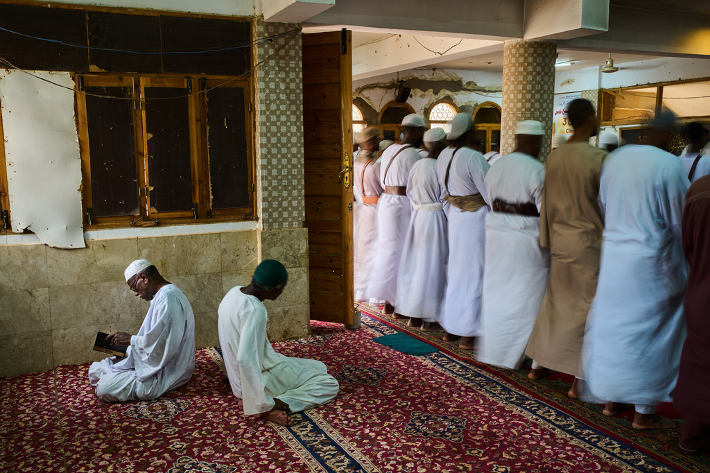 An elderly Muslim man prays while others perform zikr, a mystical Sufi ceremony, inside the war-damaged Sheikh GaribAllah Mosque in Omdurman, on the outskirts of Khartoum, Sudan, Friday, April 24, 2026. (AP Photo/Bernat Armangue)