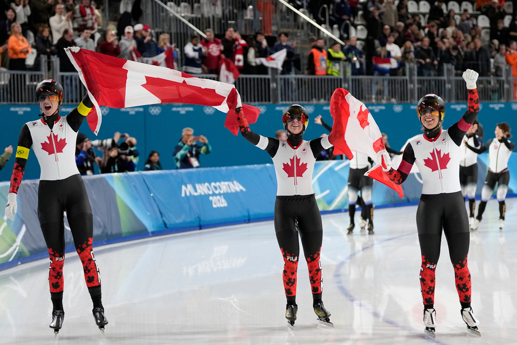 Team Canada with Ivanie Blondin, white armband, Valerie Maltais, red armband, Isabelle Weidemann, yellow armband, celebrate winning the gold medal in the final of the women's team pursuit speedskating race at the 2026 Winter Olympics, in Milan, Italy, Tuesday, Feb. 17, 2026. (AP Photo/Ben Curtis)