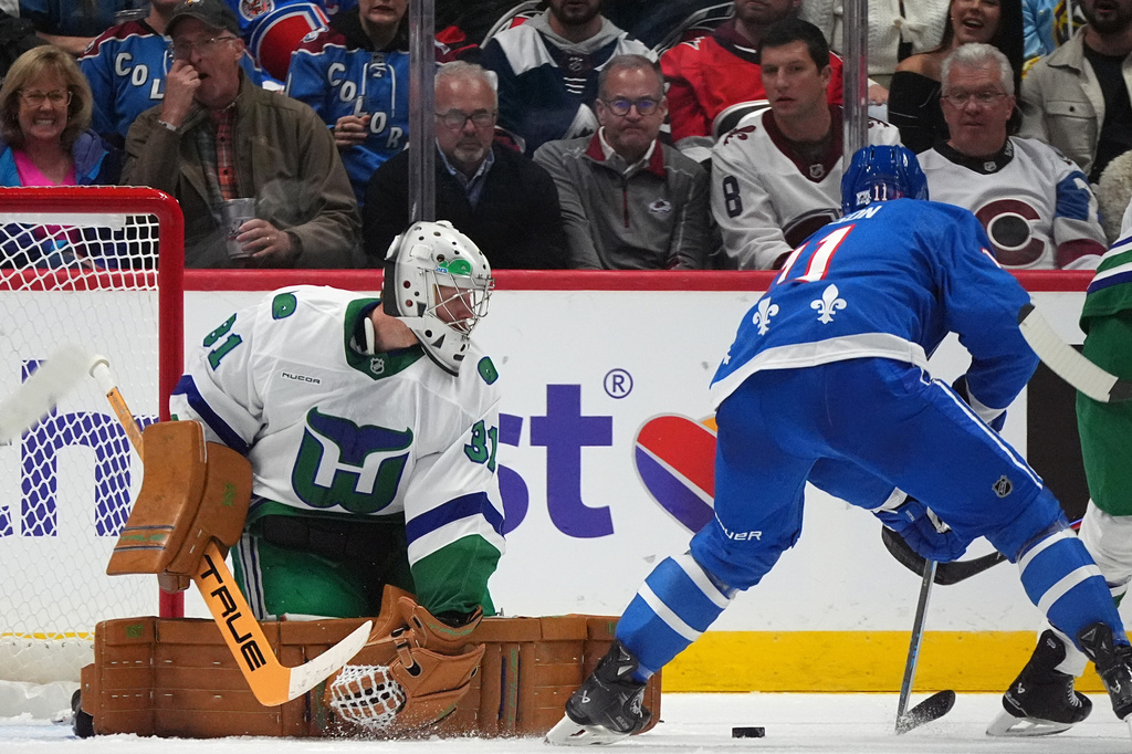 Carolina Hurricanes goaltender Frederik Andersen, left, deflects a shot from Colorado Avalanche center Brock Nelson in the second period of an NHL hockey game, Thursday, Oct. 23, 2025, in Denver. (AP Photo/David Zalubowski)