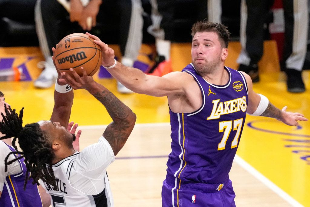 San Antonio Spurs guard Stephon Castle, left, has his shot blocked by Los Angeles Lakers guard Luka Doncic during the first half of an NBA basketball game Wednesday, Nov. 5, 2025, in Los Angeles. (AP Photo/Mark J. Terrill)