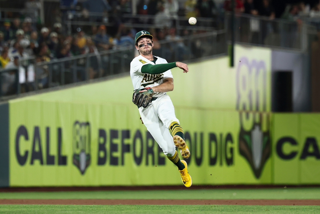 FILE - Athletics shortstop Jacob Wilson throws to first base during the seventh inning of a baseball game against the Kansas City Royals in West Sacramento, Calif., Sept. 27, 2025. (AP Photo/Sara Nevis, File)
