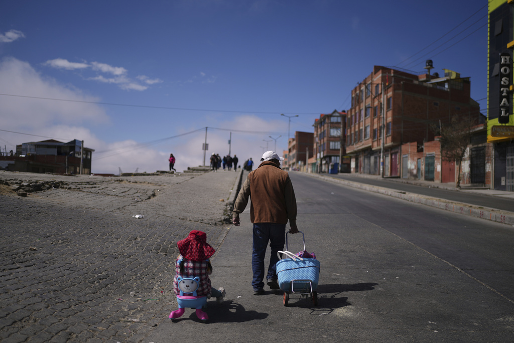 Residents walk along a street closed to traffic on election day in El Alto, Bolivia, Sunday, Aug. 17, 2025. (AP Photo/Natacha Pisarenko)