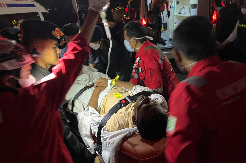 In this photo taken with a smartphone, rescuers wheels a survivor of a sinking ferry on a stretcher upon arrival at a port in Banjarmasin, South Kalimantan, Indonesia, Sunday, Sept. 13, 2026. (AP Photo/Iman Satria)