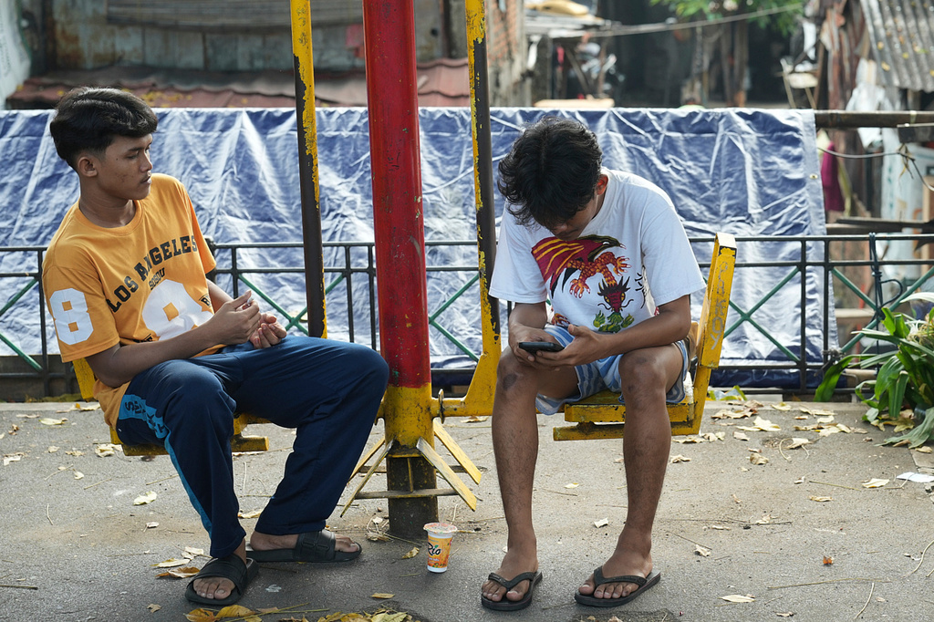 A man uses his mobile phone in Jakarta, Indonesia, Wednesday, April 29, 2026. (AP Photo/Achmad Ibrahim)