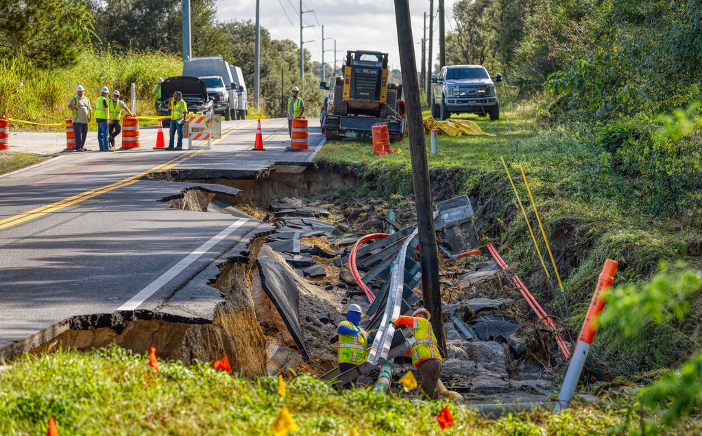 A crew works on a washed out road at Timberlake Drive after flooding damage in Lake County on Monday, Oct. 27, 2025 in Mt. Dora, Fla. (Ricardo Ramirez Buxeda/Orlando Sentinel via AP)