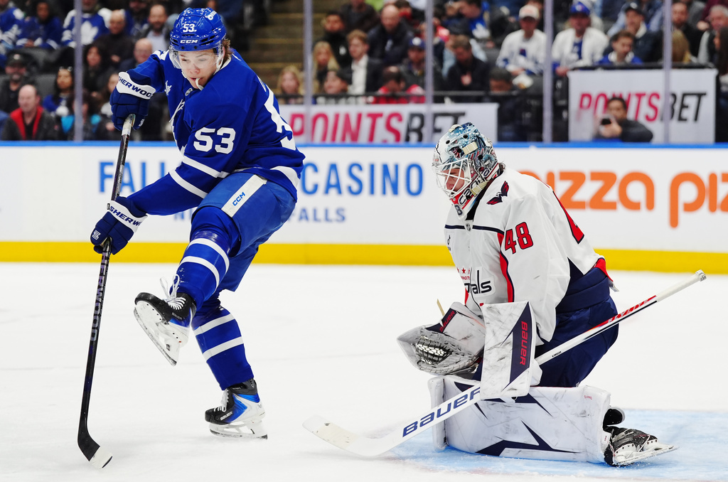 Toronto Maple Leafs' Easton Cowan (53) tries to tip the puck in front of Washington Capitals goaltender Logan Thompson (48) during second period NHL hockey action in Toronto on Wednesday, April 8, 2026. (Frank Gunn/The Canadian Press via AP)