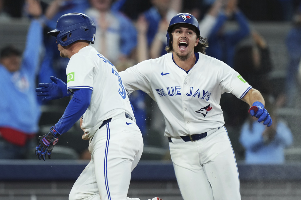 Toronto Blue Jays' Myles Straw (left) celebrates scoring the winning run against the Houston Astros with Addison Barger in tenth inning MLB baseball action in Toronto on Tuesday, Sept. 9, 2025. (Nathan Denette/The Canadian Press via AP)