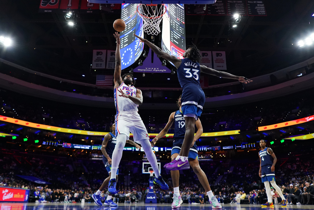 Philadelphia 76ers' Joel Embiid (21) goes up for a shot past Minnesota Timberwolves' Leonard Miller (33) during the first half of an preseason NBA basketball game Friday, Oct. 17, 2025, in Philadelphia. (AP Photo/Matt Slocum)