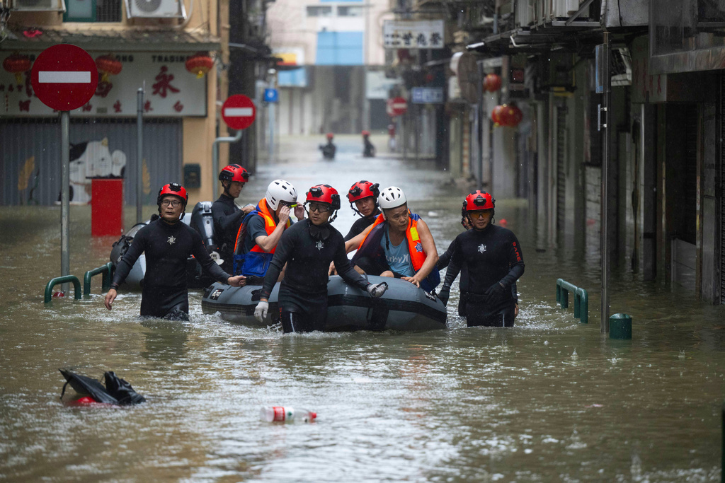 In this photo released by Xinhua News Agency, members from the local customs authority help stranded citizens to evacuate from an inundated street as Super typhoon Ragasa past nearby Macao in southern China, Sept. 24, 2025. (Cheong Kam Ka/Xinhua via AP)