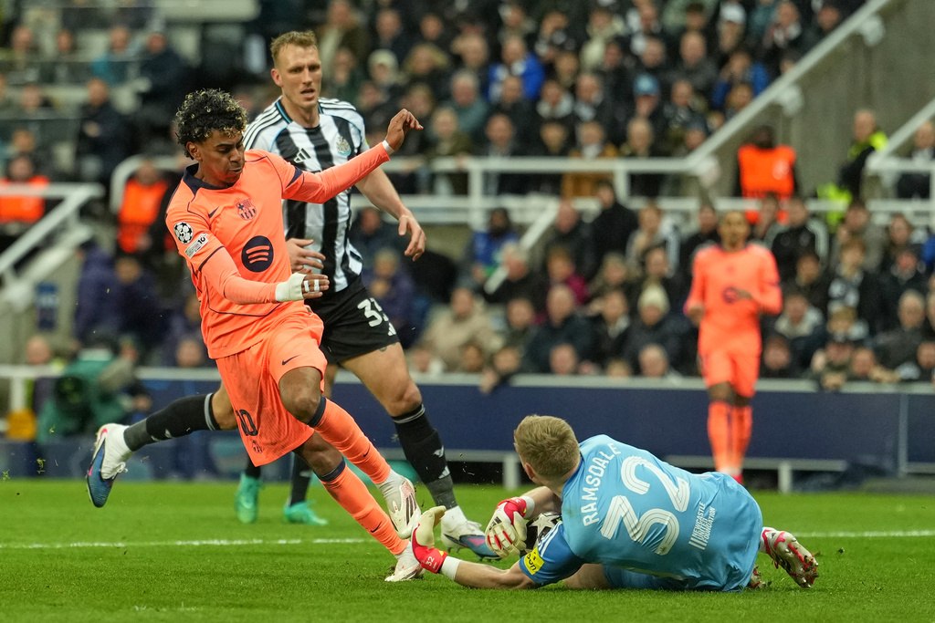 Newcastle's goalkeeper Aaron Ramsdale saves at the feet of Barcelona's Lamine Yamal during the Champions League round of 16 first leg soccer match between Newcastle United and Barcelona in Newcastle , England, Tuesday, March 10, 2026. (AP Photo/Jon Super)