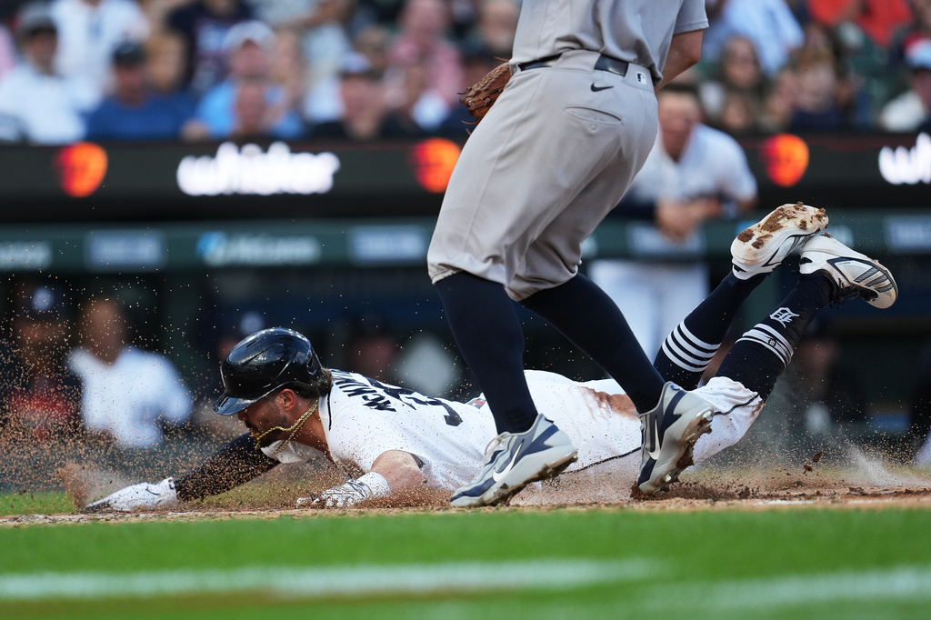 Detroit Tigers' Zach McKinstry slides safely into home plate as New York Yankees pitcher Carlos Rodón covers his wild pitch during the third inning of a baseball game Tuesday, June 23, 2026, in Detroit. (AP Photo/Paul Sancya)