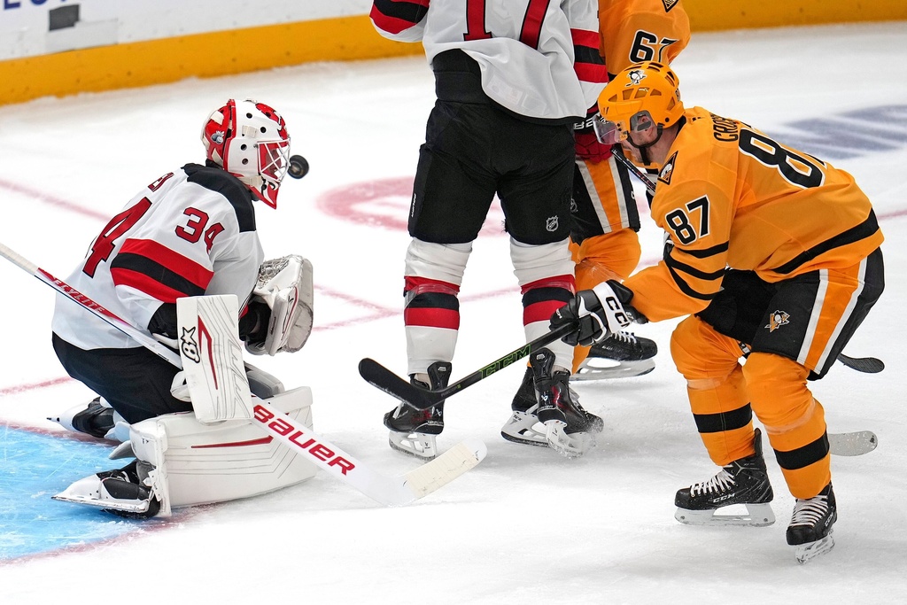 New Jersey Devils goaltender Jake Allen (34) blocks a shot by Pittsburgh Penguins' Sidney Crosby (87) during the first period of an NHL hockey game in Pittsburgh, Thursday, Jan. 8, 2026. (AP Photo/Gene J. Puskar)
