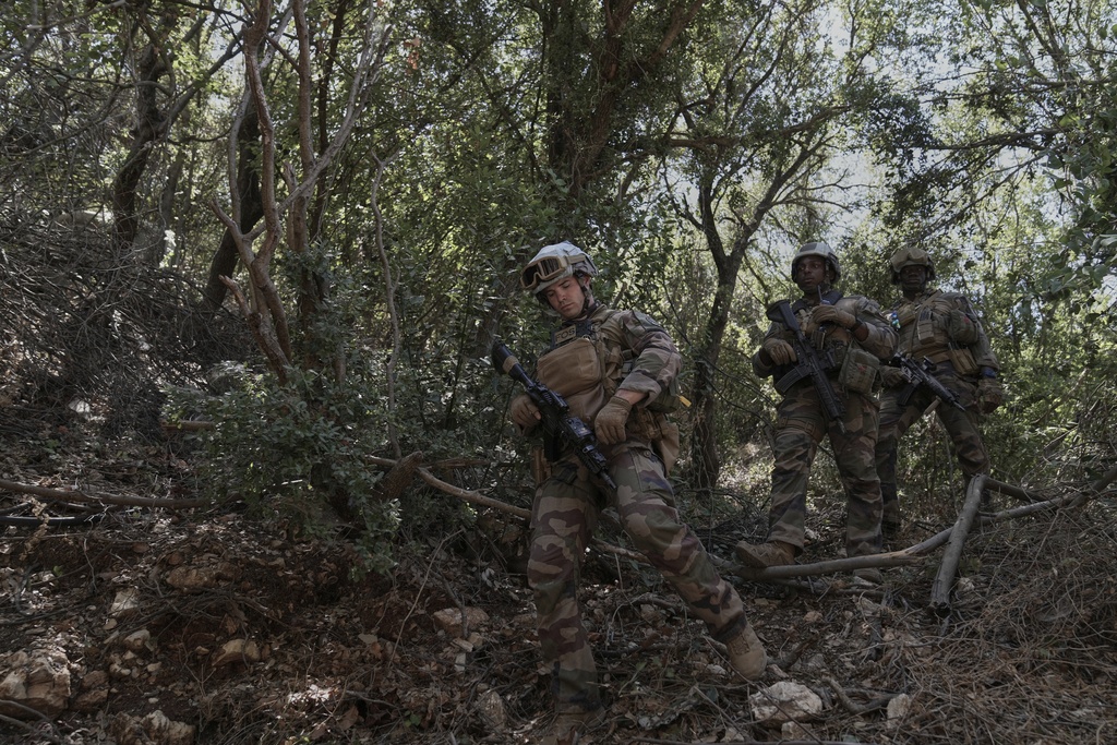 French U.N. peacekeepers walk through bushes as they search for Hezbollah weapons in the Saluki Valley, south Lebanon, Wednesday, Aug. 20, 2025. (AP Photo/Hussein Malla)