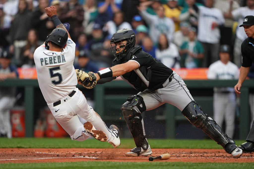 Chicago White Sox catcher Drew Romo tags out Seattle Mariners' Jhonny Pereda at home on a double from Randy Arozarena, but is counted as a run scored after a review determined second baseman Sam Antonacci committed interference on the base path during the third inning of a baseball game, Monday, May 18, 2026, in Seattle. (AP Photo/Lindsey Wasson)