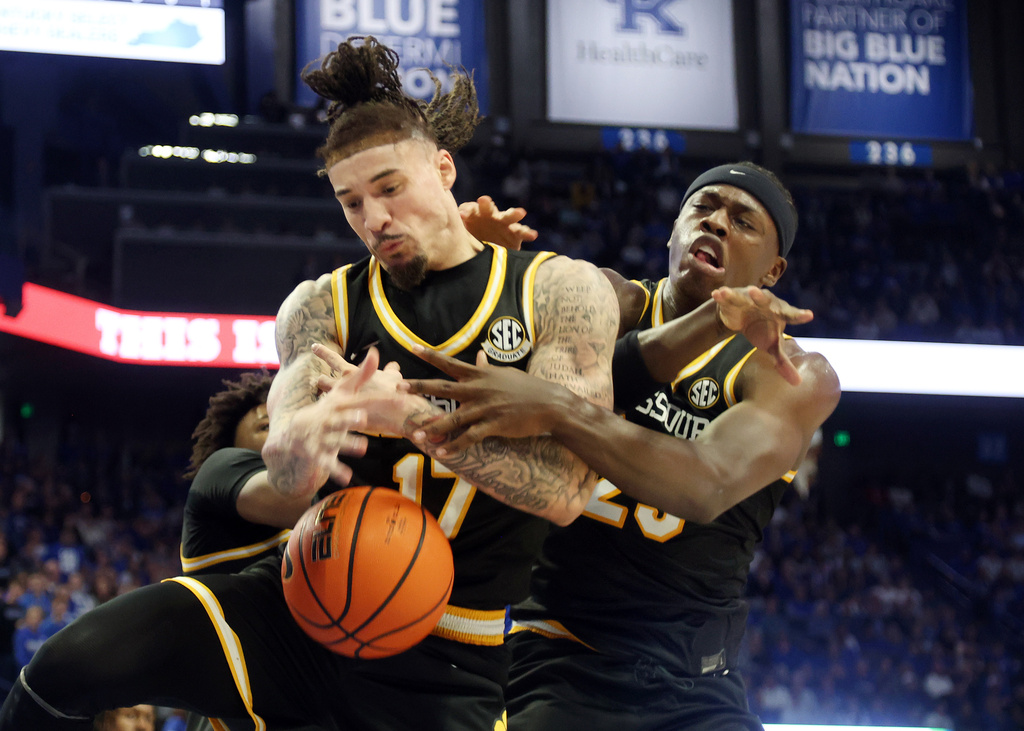 Missouri's Jayden Stone, left, and Mark Mitchell, right, fight for a rebound during the first half of an NCAA college basketball game against Kentucky in Lexington, Ky., Wednesday, Jan. 7, 2026. (AP Photo/James Crisp)