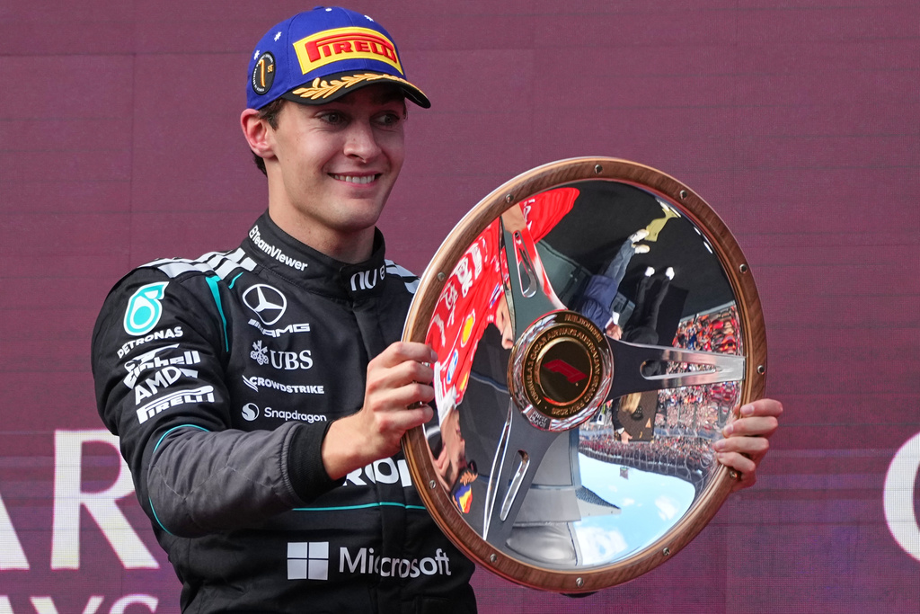 Mercedes driver George Russell of Britain celebrates on the podium with his trophy after winning the Australian Formula One Grand Prix at Albert Park, in Melbourne, Australia, Sunday, March 8, 2026. (AP Photo/Scott Barbour)