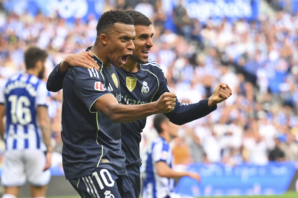 Real Madrid's Kylian Mbappe, left, and Real Madrid's Dani Ceballos react during the La Liga soccer match between Real Sociedad and Real Madrid at the Reale Arena in San Sebastian, Spain, Saturday, Sept. 13, 2025. (AP Photo/Miguel Oses)
