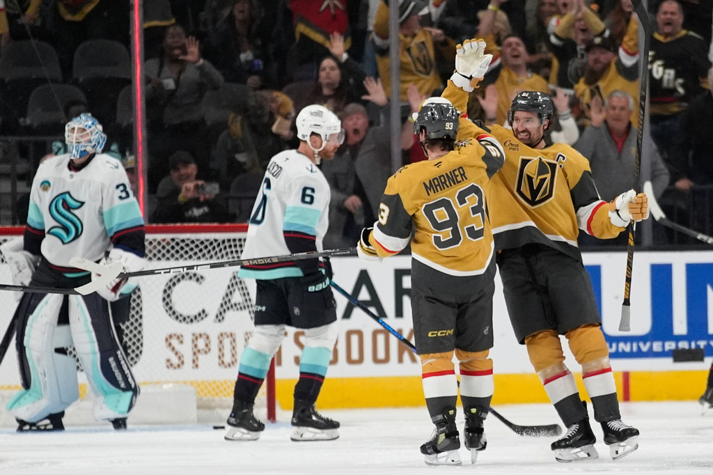 Vegas Golden Knights right wing Mark Stone, right, celebrates after Vegas Golden Knights right wing Mitch Marner (93) scored against the Seattle Kraken during the third period of an NHL hockey game Wednesday, April 15, 2026, in Las Vegas. (AP Photo/John Locher)