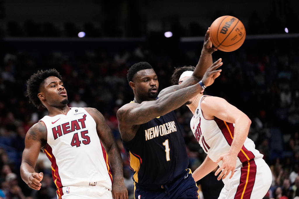 New Orleans Pelicans forward Zion Williamson (1) passes around Miami Heat guard Davion Mitchell (45) in the first half of an NBA basketball game, Wednesday, Feb. 11, 2026, in New Orleans. (AP Photo/Gerald Herbert)