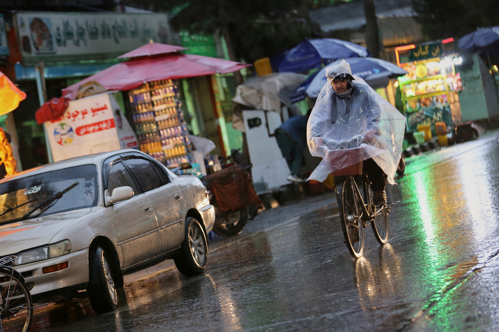 A man rides a bicycle through heavy rain in Kabul, Afghanistan, Tuesday, March 31, 2026. (AP Photo/Siddiqullah Alizai)