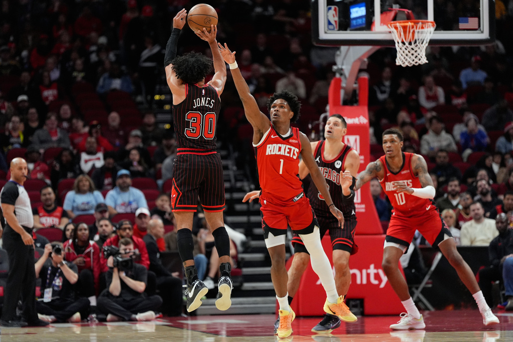 Chicago Bulls guard Tre Jones (30) shoots against Houston Rockets guard Amen Thompson (1) during the first half of an NBA basketball game in Houston, Tuesday, Jan. 13, 2026. (AP Photo/Ashley Landis)
