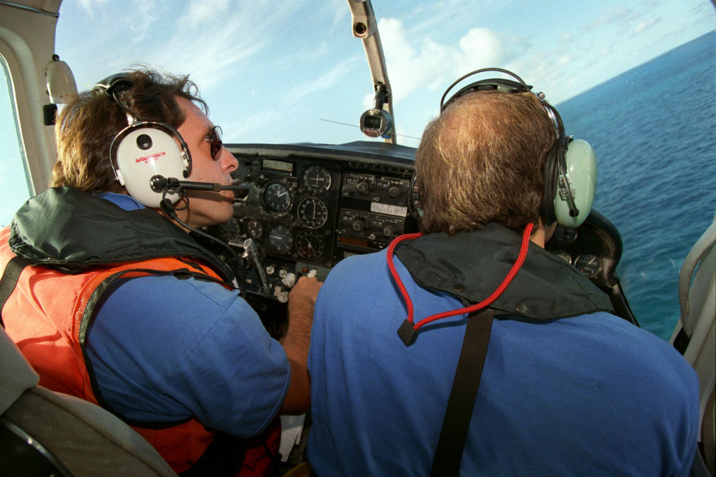 FILE - Brothers to the Rescue pilot Ivan Domaniewicz, left, and co-pilot Carlos Costa fly over the Straits of Florida looking for people who might have been on makeshift rafts fleeing Cuba in August 31, 1993. (AP Photo/Lynne Sladky, File)