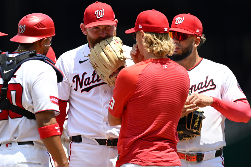 Washington Nationals starting pitcher Zack Littell has a conference with Nationals pitching coach Simon Mathews during the second inning of a baseball game against the Kansas City Royals, Wednesday, June 17, 2026, in Washington. (AP Photo/John McDonnell)