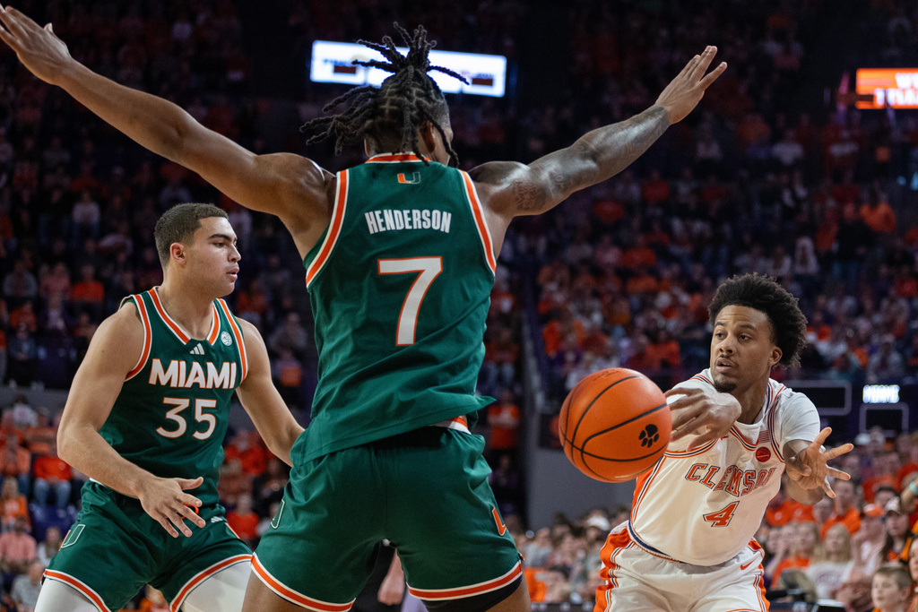 Clemson guard Efrem Johnson (4) passes around Miami forward Shelton Henderson (7) during the first half of an NCAA college basketball game Saturday, Jan. 17, 2026, in Clemson, S.C. (AP Photo/Scott Kinser)