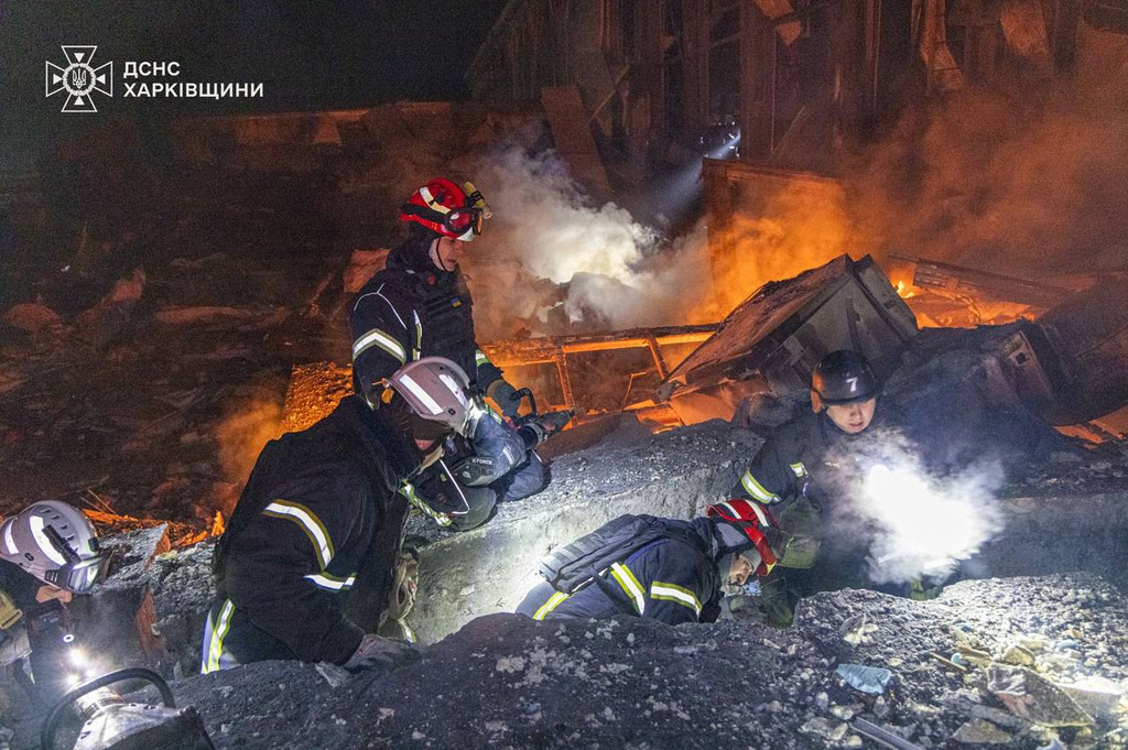 In this photo provided by the Ukrainian Emergency Service, emergency services personnel work to extinguish a fire following a Russian attack in Kharkiv, Ukraine, Tuesday, Jan. 13, 2026. (Ukrainian Emergency Service via AP)