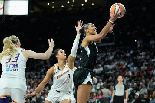 Las Vegas Aces center A'ja Wilson (22) shoots as Phoenix Mercury guard Sami Whitcomb (33) and forward Satou Sabally (0) defend during the second half in Game 2 of the WNBA basketball finals, Sunday, Oct. 5, 2025, in Las Vegas. (AP Photo/John Locher) Las Vegas Aces center A'ja Wilson (22) shoots as Phoenix Mercury guard Sami Whitcomb (33) and forward Satou Sabally (0) defend during the second half in Game 2 of the WNBA basketball finals, Sunday, Oct. 5, 2025, in Las Vegas. (AP Photo/John Locher)
