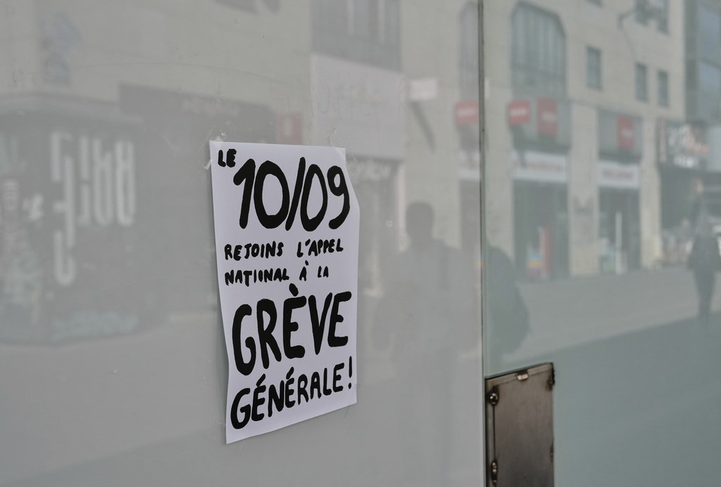 A leaflet is pined on a window reads "September 10, answer the national call and join the general strike" in Paris, Tuesday, Sept. 9, 2025, at the eve of a national protest. (AP Photo/Aurelien Morissard)