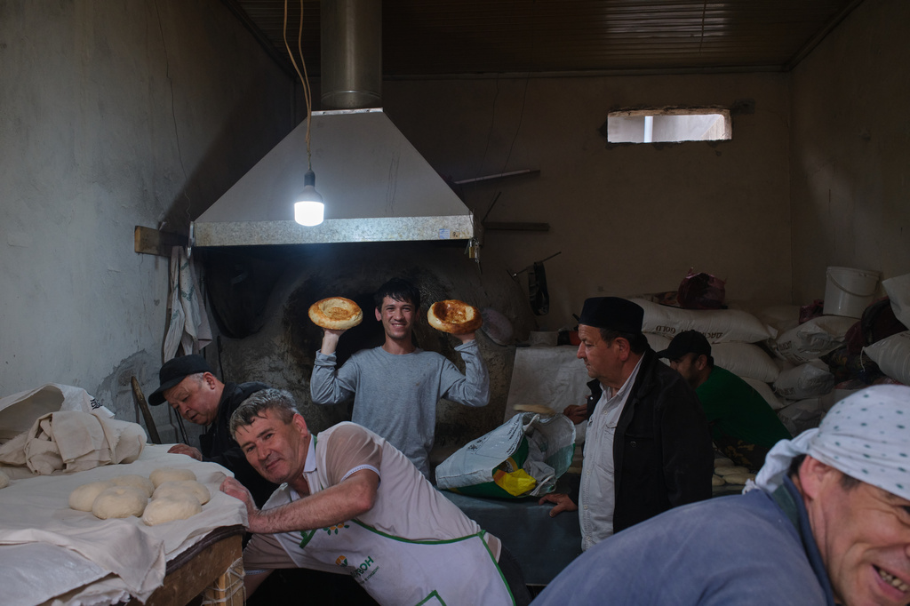 A baker shows off fresh non bread known as lepyoshka, in Khujand, Tajikistan, Sunday, May 3, 2026. (AP Photo/Jon Orbach)