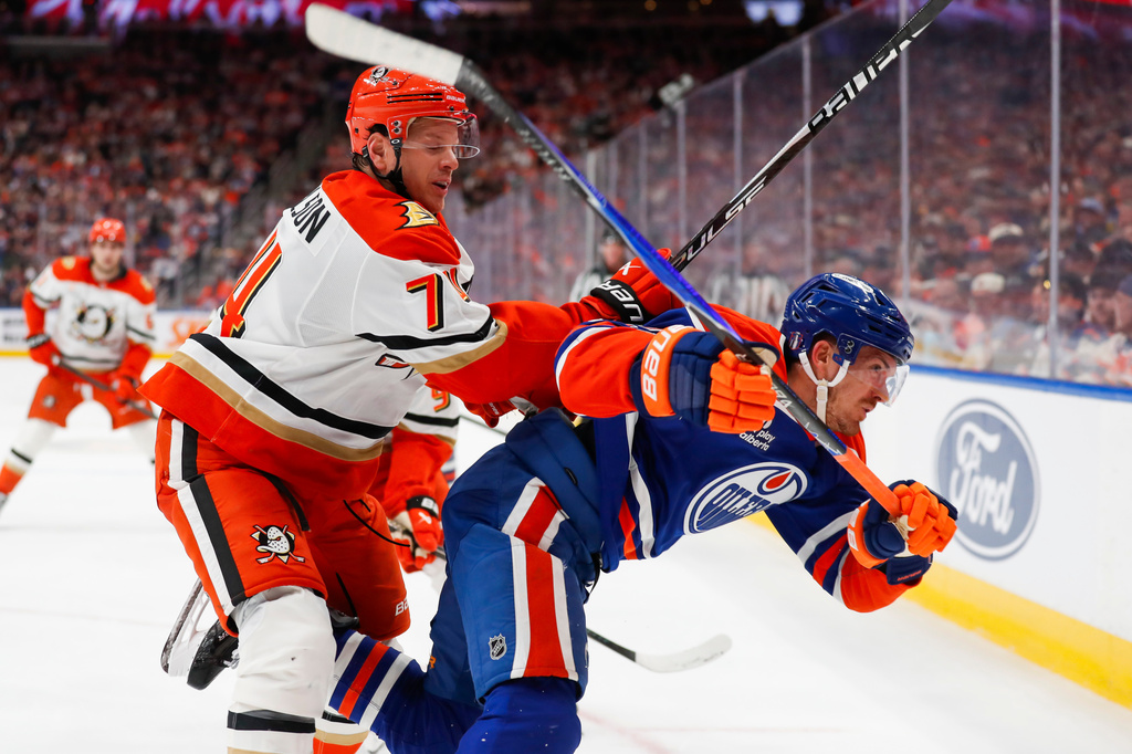 Anaheim Ducks' John Carlson (74) hits Edmonton Oilers' Jack Roslovic (28) during the second period of an NHL hockey playoff game in Edmonton, Alberta, on Wednesday, April 22, 2026. (Codie McLachlan/The Canadian Press via AP)
