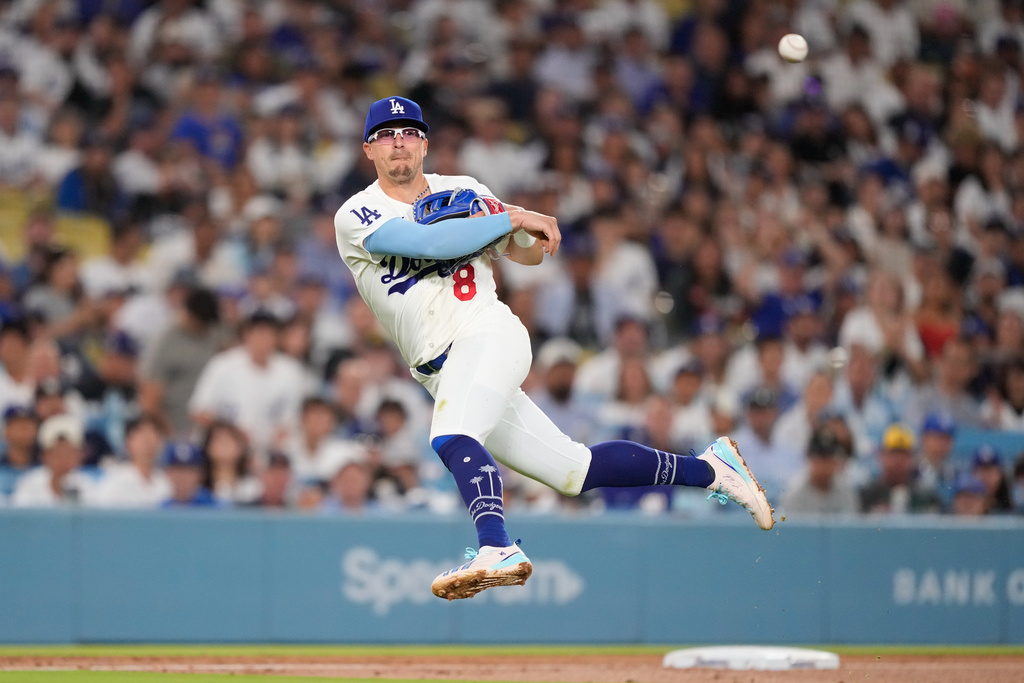 Los Angeles Dodgers third baseman Kiké Hernández throws out Milwaukee Brewers' Jake Bauers at first during the fifth inning of a baseball game Thursday, Aug. 13, 2026, in Los Angeles. (AP Photo/Mark J. Terrill)