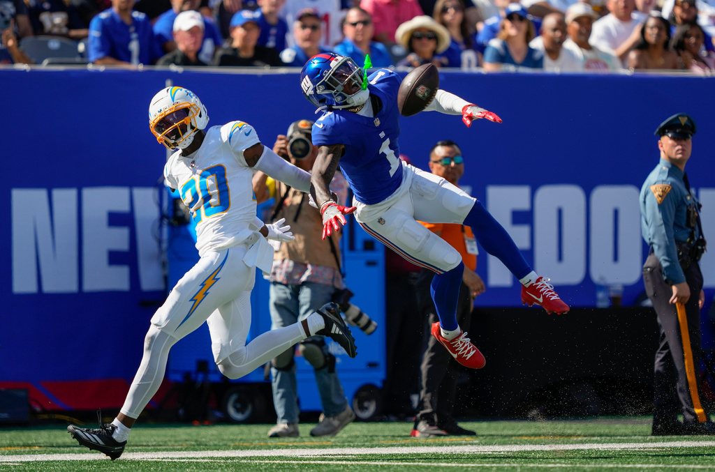 New York Giants wide receiver Malik Nabers (1) reacts as he leaps for a pass against Los Angeles Chargers cornerback Cam Hart (20) during the second quarter of an NFL football game, Sunday, Sept. 28, 2025, in East Rutherford, N.J. (AP Photo/Yuki Iwamura)