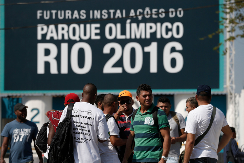 FILE - Striking workers stand in front the entrance of the Olympic Park, the main cluster of venues under construction for the 2016 Summer Olympic Games, in Rio de Janeiro, Brazil, April 8, 2014. (AP Photo/Silvia Izquierdo, File)