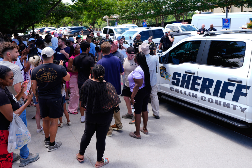 A crowd gathers by Collin County Sheriffs vehicles parke in front of the Collin County courthouse after the Karmelo Anthony verdict was reached Tuesday, June 9, 2026, in McKinney, Texas. (AP Photo/Tony Gutierrez)