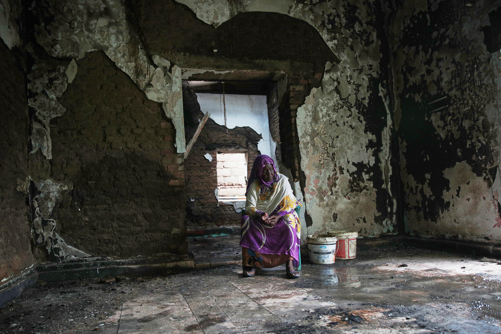 Afaf El-Tayeb, 63, sits at her damaged and looted home after her return, following the fighting between the Sudanese Armed Forces (SAF) and the paramilitary Rapid Support Forces (RSF), in Khartoum, Sudan, Friday, Aug. 15, 2025. (AP Photo/Marwan Ali)