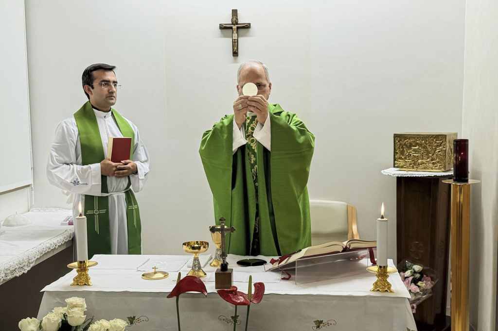 This picture, released by Vatican Media on Friday, Oct. 16, 2026, shows Pope Leo XIV, flanked by his personal secretary, Monsignor Edgard Iv&aacute;n Rimaycuna Inga, left, celebrating Mass at the Agostino Gemelli Polyclinic in Rome, where he is recovering after having cancer removed from his right lung. (Vatican Media via AP)