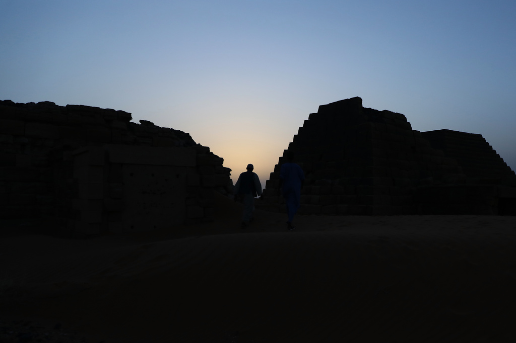 A visitor walks among the Meroe pyramids at the Meroe archaeological site in Bejrawiya, Sudan, Saturday, Aug. 1, 2026. (AP Photo/Mohnd Blal)