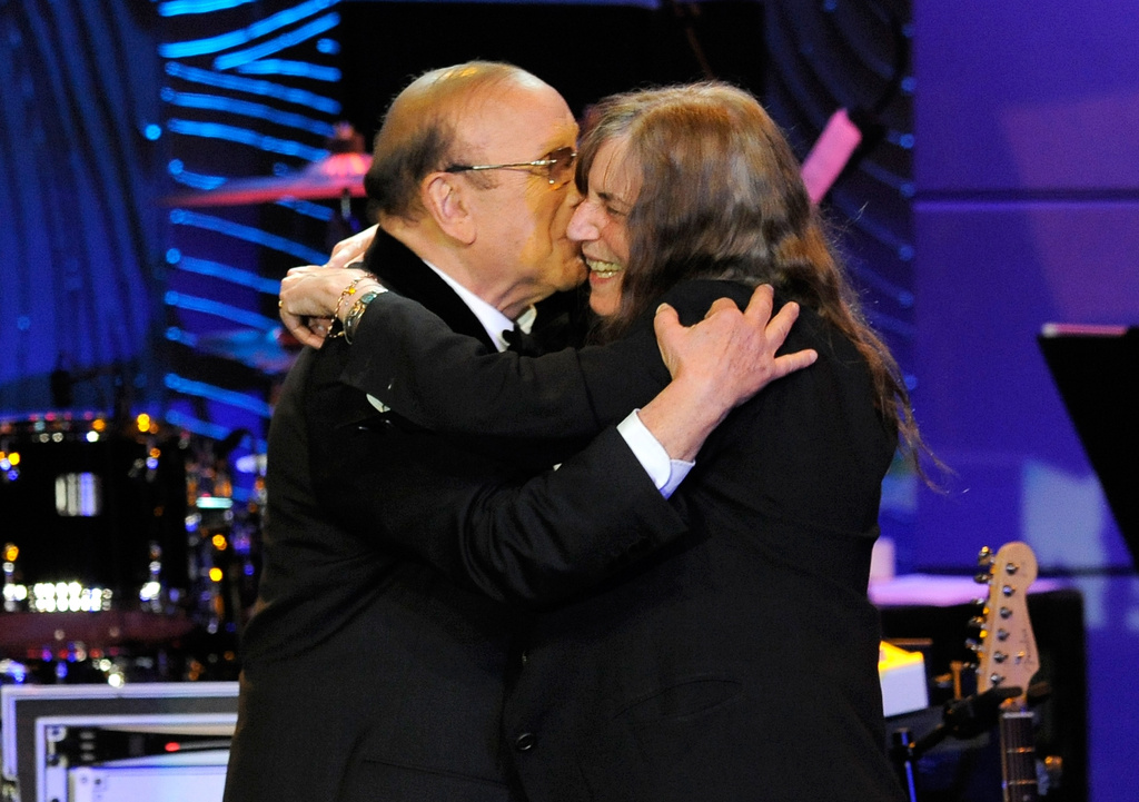 FILE - Music producer Clive Davis, left, and recording artist Patti Smith embrace onstage at the Clive Davis Pre-Grammy Gala in Beverly Hills, Calif., on Feb. 9, 2013. (Photo by Chris Pizzello/Invision/AP, File)