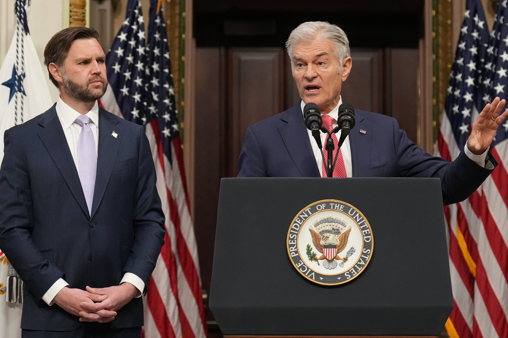 Vice President JD Vance listens as Centers for Medicare & Medicaid Services Administrator Dr. Mehmet Oz speaks to the media from the Eisenhower Executive Office Building on the White House campus, Wednesday, May 13, 2026, in Washington. (AP Photo/Jacquelyn Martin)