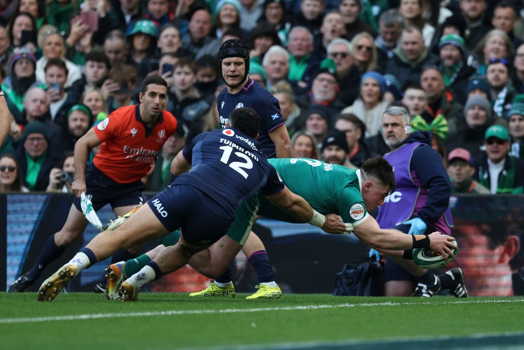 Ireland's Dan Sheehan, right, dives over the line to score a try as Scotland's captain Sione Tuipulotu tries to tackle him during the Six Nations rugby union match between Ireland and Scotland, in Dublin, Saturday, March 14, 2026. (AP Photo/Peter Morrison)