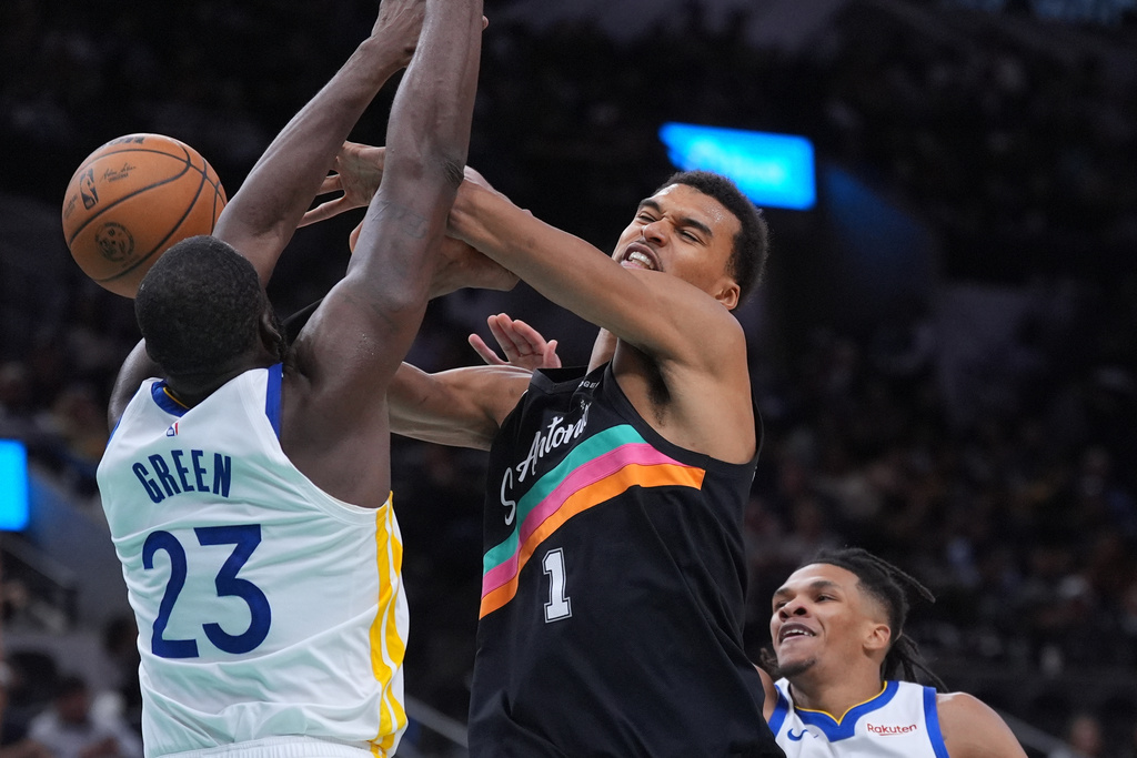 San Antonio Spurs forward Victor Wembanyama (1) is fouled by Golden State Warriors forward Draymond Green (23) during the second half of an NBA basketball game in San Antonio, Wednesday, Nov. 12, 2025. (AP Photo/Eric Gay)